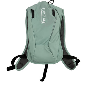 A sage green CamelBak hydration pack with black straps and gray padding, shown from the back against a plain white background.