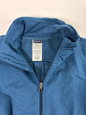 A close-up of a blue heather zip-up hoodie showing the inner collar with a Patagonia brand tag and a silver zipper pull.