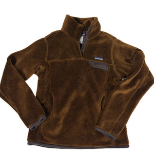 A brown fleece pullover jacket with a quarter-zip collar and a small chest pocket, laid flat on a light gray background. The brand label on the chest pocket is visible as Patagonia.